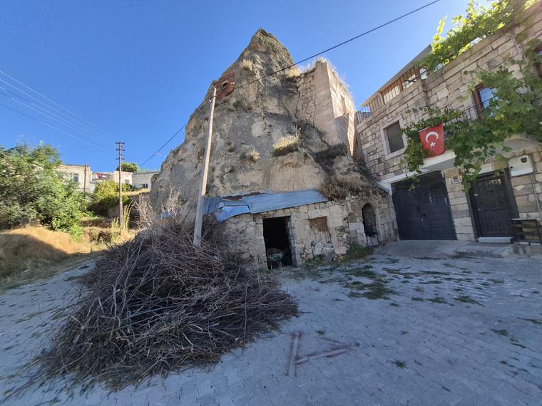 Köy evlerinin arasında kilisenin oyulduğu peribacası konisi